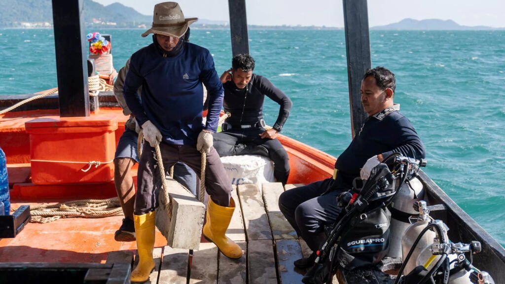 Baie de Kep. Des volontaires rémunérés transportent chaque bloc de 100kg de la proue à la poupe avant qu'ils ne soient largués puis assemblés par les plongeurs sous l'eau.