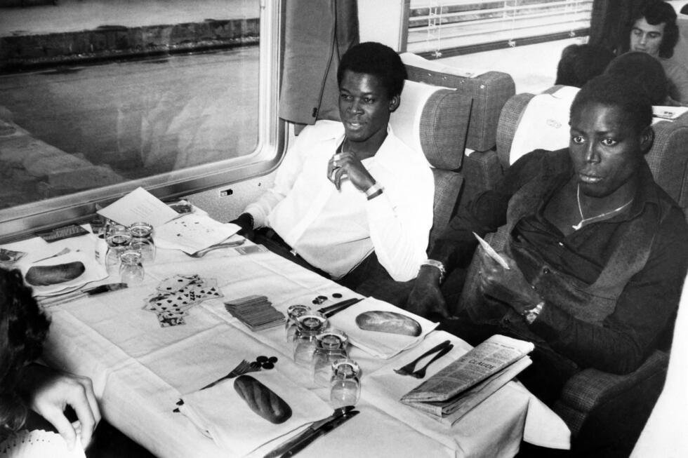 Photo prise le 11 octobre 1974, montrant les joueurs de l'équipe de France de football, Marius Trésor (à droite) et Jean-Pierre Adams, quittant Paris en train pour Bruxelles afin d'affronter l'équipe de Belgique dans le cadre des qualifications pour le Championnat d'Europe.