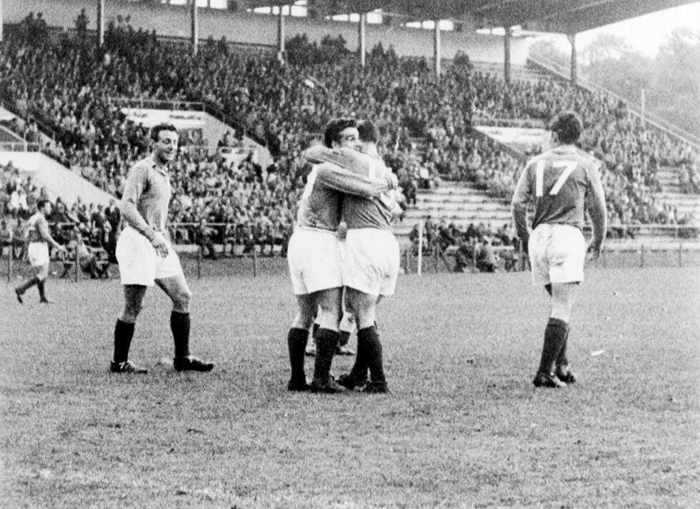 L'attaquant français Maryan Wisnieski (au centre, à droite) est félicité par son coéquipier Roger Piantoni après avoir inscrit le premier but de son équipe, sous le regard de l'attaquant Jean Vincent (à gauche), le 19 juin 1958 à Norrköpping, lors du quart de finale de la Coupe du monde opposant la France à l'Irlande du Nord. La France s'est qualifiée pour les demi-finales grâce à une victoire 4-0 contre l'Irlande du Nord.