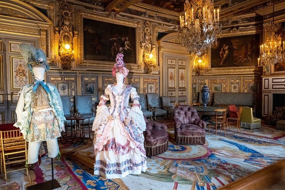 Costumes d’un et d’une artiste de choeur en noble dans le salon Louis XIII pour l’exposition « Marie-Antoinette de l’avant-garde à l’avant-scène. Costumes de scène créés par Christian Lacroix » au château de Fontainebleau